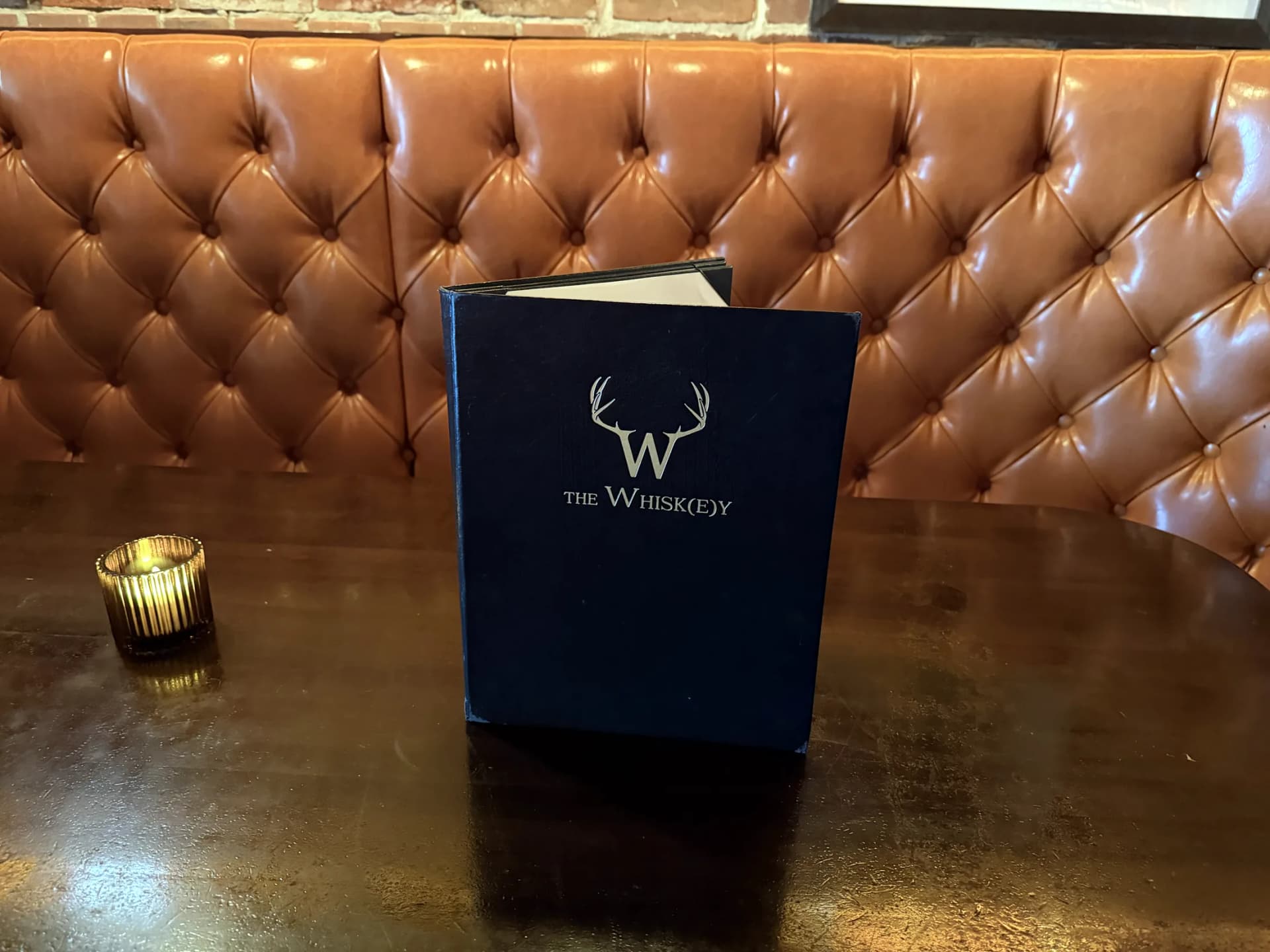 Menu and candle on a booth table